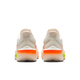 Et par Nike Zoom Fly 6 Dame-sko i Pale Ivory/Hyper Crimson, vist bagfra med en hvid overdel, orange og grønne detaljer og en struktureret sål. Skoene står side om side på en hvid baggrund.