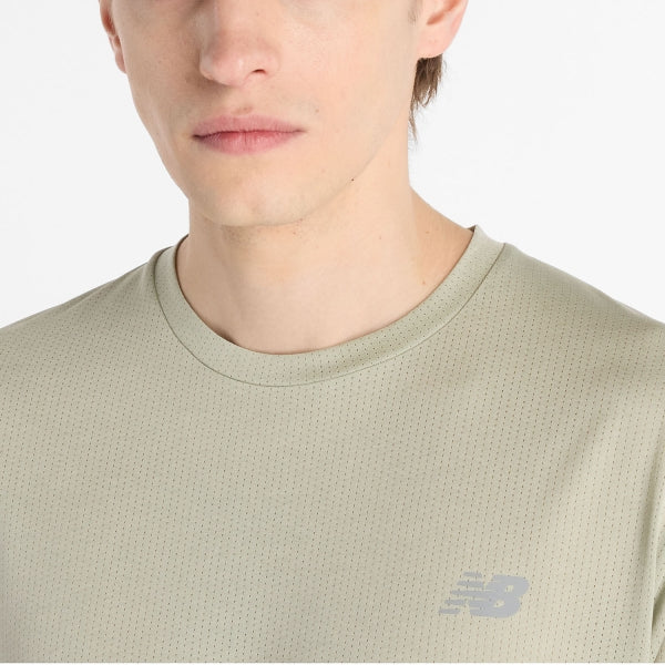 Et nærbillede viser en person iført New Balance Athletics T-Shirt, Herre, i Garter Snake Heather. Det diskrete netmønster og logoet på venstre bryst er synligt; kun underansigtet og overkroppen ses.