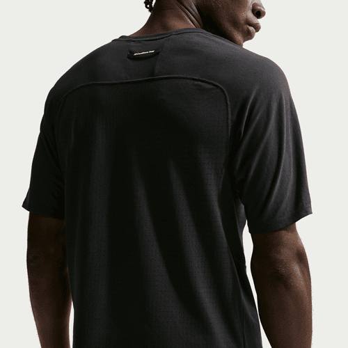 En person ses bagfra iført en Nike ACG "Solar Chase" Trail Running Top (Herre, Black/Black/Summit White), hvor mærket er synligt øverst på ryggen mod en almindelig hvid baggrund.