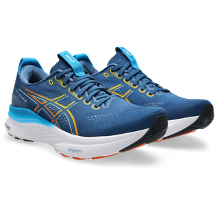 Et par Asics Gel-Kayano 32 herre løbesko i Twilight Blue/Anzu med gule og orange detaljer, hvide mellemsåler, sorte ydersåler og blå snørebånd. Skoene står side om side, let vinklet mod højre.