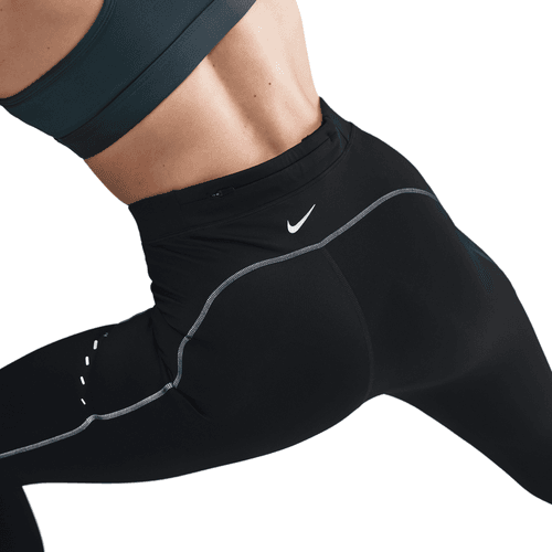 En person i en mørk sports-bh og Nike Therma-FIT ADV High-Waisted 7/8 Reflective Running Leggings (Black/Dk Smoke Grey) kaster sig ud i det. Leggingsene har reflekspiping, et lille logo i linningen og avanceret varmeteknologi.
