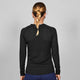 En person med en enkelt fletning kigger væk fra kameraet og er iført Saysky Mesh Base Layer Long Sleeve i sort (unisex) sammen med blå bukser på en almindelig grå baggrund.
