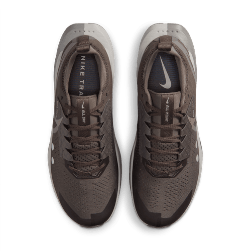 Et par Nike Zegama 2 løbesko til mænd i Ironstone/Cave Stone-College Grey, set ovenfra, med snørebånd, perforeret overdel og swoosh-logoer på tungen og indersålen. Ideelle til tekniske stier med komfort og greb.
