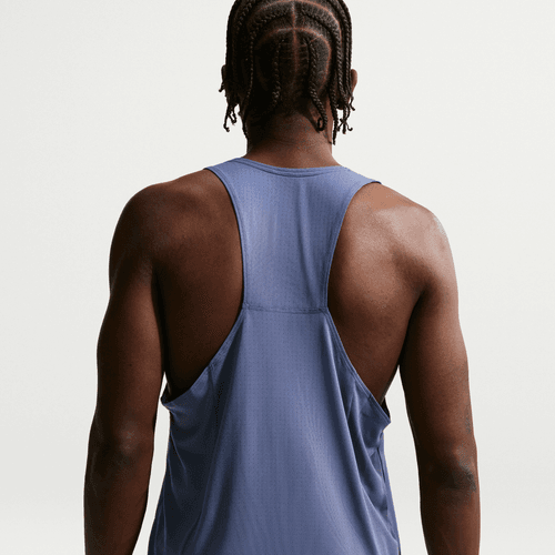 En person med flettet hår ses bagfra iført en Nike Nk Df Fast Singlet til mænd i Diffused Blue/Reflective Silver på en almindelig lys baggrund.