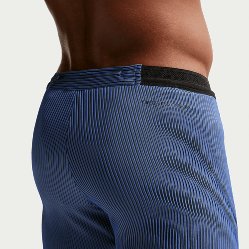 Et nærbillede fra siden viser en person iført Nike Dfadv Aroswft Bf Htight til mænd i Game Royal/Diffused Blue/Obsidian/Black, der fremhæver den sorte linning, taljen og den øverste del af hoften for at vise stoffets tekstur og pasform.