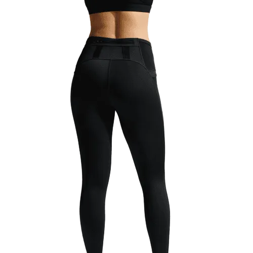 En kvinde ses bagfra iført Nike ACG High-Waisted 7/8 Running Tights i Black/Summit White, med synlige sømme og en lomme i linningen, sammen med en sort sports-bh på en almindelig hvid baggrund.