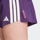 Nærbillede af en person iført Adidas Adizero Gel Dame Aurplu shorts i lilla med hvide striber, med "ADIZERO" i pink og et hvidt Adidas-logo på venstre side.
