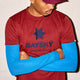 En person er iført en rød Saysky Logo Combat Pro T-shirt og en matchende kasket med en marineblå stjerne, lyseblå ærmer indenunder og har armene over kors.