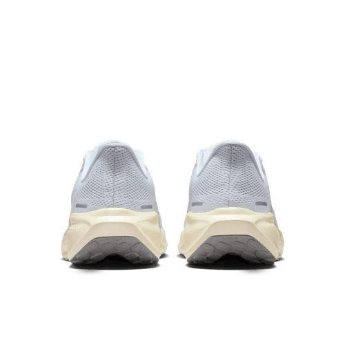 Et par Nike Pegasus 41 ESS damesko i White/White-Chalk-Sea Glass, vist bagfra på en hvid baggrund. Disse sko har mesh-lignende tekstur og tykke beige såler, der sikrer enestående komfort for hvert skridt.