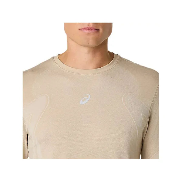 En mand er iført Asics Road Seamless Ls Top, Herre, Cream. Kun hans underansigt og overkrop er synlige, og man kan se et lille hvidt Asics-logo på brystet.