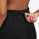 En hånd åbner den lille lynlåslomme i linningen på Nike Dri-FIT High-Waisted 4" Tight Running Shorts til kvinder i sort og viser et nærbillede af bagsiden mod en ensfarvet baggrund.