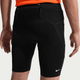 En person er iført sorte Nike ACG Lavaloops 1/2 Tights, Herre, Black/Summit White med synlige sømme og et hvidt logo på venstre ben. Træningstøjet har en lynlåslomme i linningen og er stylet med en orange top set bagfra.