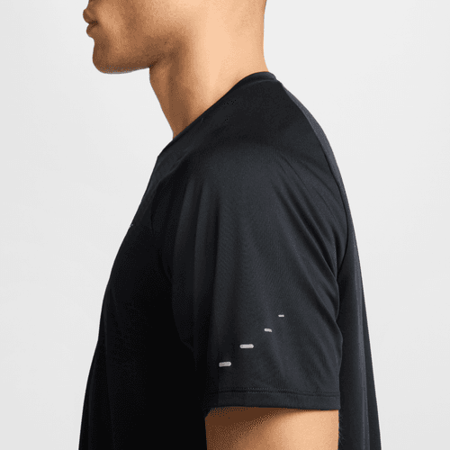 En mand ses fra siden iført en sort Nike Stride SS Running Top (Herre, Black/Reflective Silver) med fire små hvide mærker synlige på Dri-FIT ADV-ærmet. Kun hans overkrop fra halsen til midt på armen er fanget.