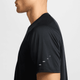 En mand ses fra siden iført en sort Nike Stride SS Running Top (Herre, Black/Reflective Silver) med fire små hvide mærker synlige på Dri-FIT ADV-ærmet. Kun hans overkrop fra halsen til midt på armen er fanget.