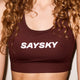 En person med krøllet hår er iført Saysky W Logo Combat Sports Bra, Dame, Red - en rødbrun racerback sports-bh med et fedt hvidt SAYSKY-logo hen over brystet. Ansigtet er ikke synligt.