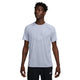 En person iført Nike Dri-FIT ADV Short-Sleeve Running Top, Herre, Ghost/Htr/Reflective Silv og sorte Nike-shorts står lidt til venstre på en almindelig hvid baggrund.