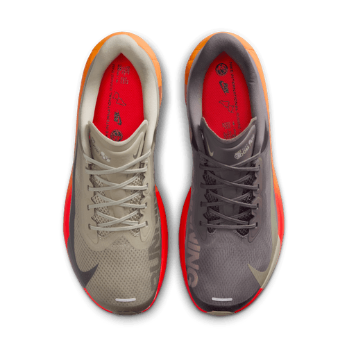 Topbillede af Nike Zoom Fly 6, Herre i Desert Khaki/Cave Stone-Monarch med uensartede farver - venstre sko er lys beige med orange hæl, højre er grå med rød hæl. Det røde interiør gør dem ideelle til tempoløb eller daglig træning.