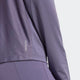 Et nærbillede viser en person i en matchende lavendelfarvet Adidas Otr B Hzip træningstrøje dame og leggings. Den langærmede top har "AEROREADY" trykt nær kanten, hvilket fremhæver det fugtabsorberende stof.