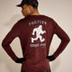 En person, der kigger væk fra kameraet, bærer en rød Saysky Statement Pace Long Sleeve, Herre, med en hvid, løbende yeti og "FARTLEK GAME ON" på ryggen.