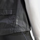 Nærbillede af Adidas Otr B Vest til kvinder i sort med WIND.RDY-tekst ved en søm, lagt over et hvidt tekstureret ærme og sort løbetøj til kvinder.