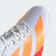 Nærbillede af Adidas Adizero Adios Pro 4 til mænd i Cloud White/Lucid Orange/Lucid Red, der viser orange striber, hvide snørebånd, ADIZERO-mærke på tungen, et subtilt gittermønster på overdelen og en del af den hvide sål.