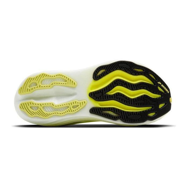 Billedet viser sålen på en Brooks Glycerin Max, Dame (Sunny Lime/Black/White), en neutral løbesko, der er kendt for maksimal komfort, med en bølget sort og gul slidbane på hvid. "BROOKS" er synlig på den sorte hælsektion.