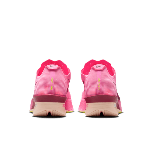 Et par Nike Vaporfly Next% 4 Dame løbesko i Pink Spell/Bordeaux-Hyper Pink-Volt Ice, set bagfra med hæl-logoer og en lysebrun sål, ideelle til maraton eller elitesko konkurrence, på en almindelig hvid baggrund.