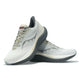 Et par Saucony Triumph 23 Herre Grey/Shadow løbesko med lysegrå overdel og sorte såler og diskrete bølgemønstre, den ene stående og den anden lænet op ad den.