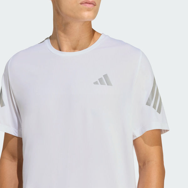 En mand er iført en Adidas Adi365 Running Tee, Herre, Hvid med lysegrå geometriske logoer på brystet og ærmerne, fotograferet fra skuldrene og op mod en ensfarvet baggrund.