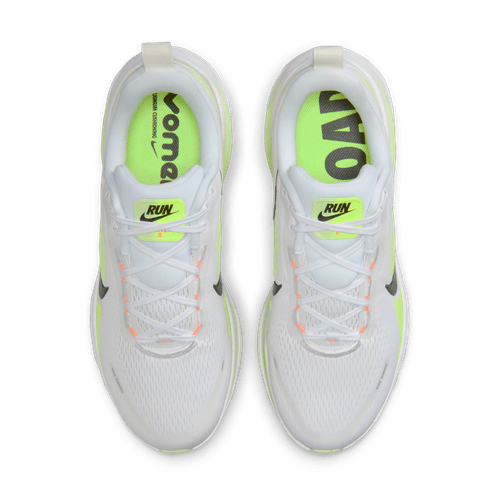 Et par Nike Vomero 18 løbesko herre i White/Black-Volt-Barely Volt, der er ideelle til komfortløbetræning, har neongrønne indlægssåler - den ene mærket VOMERO, den anden ROAD - plus hvide snørebånd og diskrete orange øjer for et elegant look.