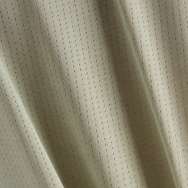 Nærbillede af New Balance Athletics Long Sleeve til kvinder i Garter Snake Heather, der består af lys beige stof med et diskret gittermønster af små, jævnt fordelte perforeringer. Det blødt draperede materiale fremhæver dets blide folder og tekstur.