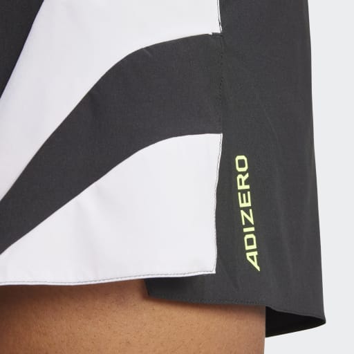 Nærbillede af en person iført Adidas Adizero Archive Gel Shorts 3" til mænd i sort, med "ADIZERO" i gult på siden og avanceret ventilation for komfort.
