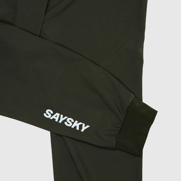 Et nærbillede af et sort ærme med SAYSKY i hvidt ved håndleddet, stilfuldt sat sammen med grønne Pace Pants til mænd fra Saysky - ideelt til at fuldende dit sportslige look.
