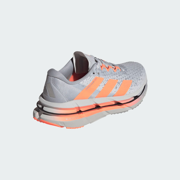 Adidas Adistar Byd løbesko dame i Clgrey/Beaora/Halsil har en struktureret grå overdel, lyse orange striber og accenter og en hvid mellemsål. Den stabile sko er fotograferet i en vinkel mod en almindelig lys baggrund.
