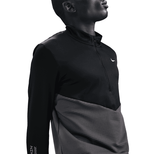 En mand ses fra skuldrene og opefter iført en Nike Pacer Winterized 1/2-Zip Running Top i Anthracite/Black/Reflective Silv. Lavvinkelbilledet klipper delvist hans ansigt ud af billedet.