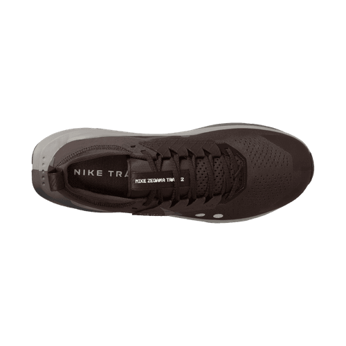 Topbillede af Nike Zegama 2, Herre i Ironstone/Cave Stone-College Grey, med en overdel i mesh med snørebånd og NIKE TRAIL-branding - ideel til tekniske stier som et stærkt trailskoalternativ ved siden af Salomon Zegama 2. Set på en almindelig hvid baggrund.