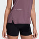 En person iført en Adidas Adi365 Hk Shafig dame singlet i mauve og sorte shorts, vist fra midt på torsoen til midt på låret, står på en almindelig lys baggrund.