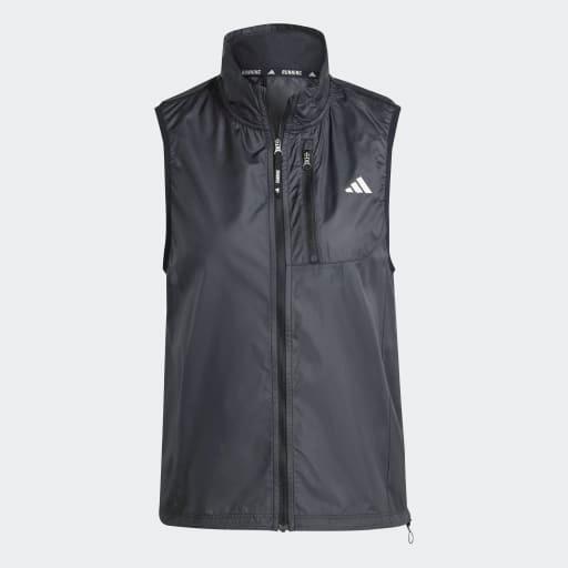 Adidas Otr B Vest til kvinder er en sort løbevest uden ærmer med lynlås foran, høj krave, lynlåslomme på brystet og et lille hvidt logo på venstre bryst. Perfekt til dame løbetøj. Vist på en ensfarvet lysegrå baggrund.
