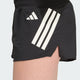 Nærbillede fra siden af en person iført Adidas Adi365 Shorts, Dame, sort-sorte sportsshorts med hvide striber og et logo på venstre lår.