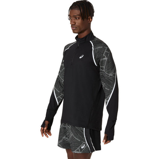 En mand er iført Asics Limited Series Lite-Show LS Top, Herre, Performance Black, en sort og grå løbetrøje med hvide detaljer, refleksdetaljer, svedtransporterende materiale og geometriske ærmemønstre, sammen med matchende shorts.