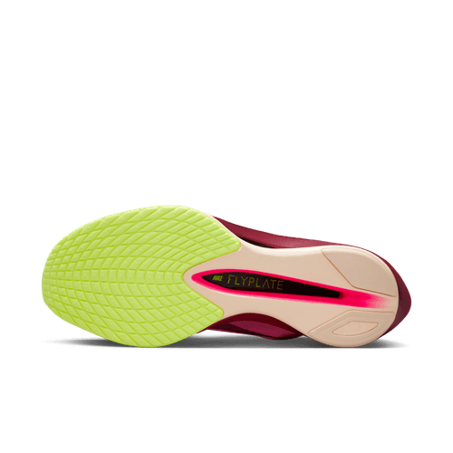 Billedet viser sålen på Nike Vaporfly Next% 4 Dame i Pink Spell/Bordeaux-Hyper Pink-Volt Ice - en af de bedste maratonløbesko. Forsiden er lysegrøn med et struktureret greb, mellemsålen har sort/rød Flyplate-tekst, og hælen er lys beige.