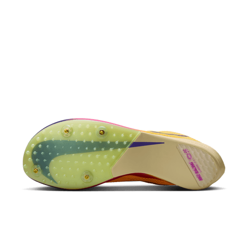Billedet viser sålen på Nike Dragonfly 2 Herre løbesko i Citron Pulse/Indigo Burst-Vivid Purple, med en gennemsigtig bund, fire pigge, et stort swoosh-logo og et pink ZoomX-mærke ved hælen.