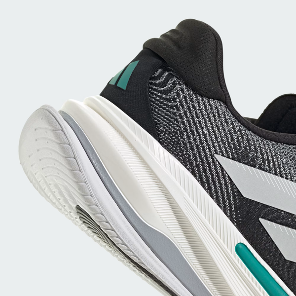 Nærbillede af hælen og siden på Adidas Supernova Prima 2, Herre i Core Black/Cloud White/Pure Teal, der viser den strukturerede overdel og den tykke, mønstrede hvide sål.