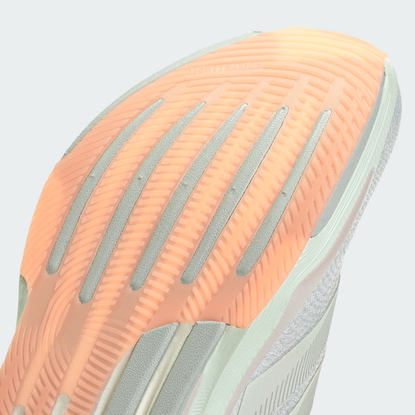 Nærbillede af sålen på Adidas Supernova Prima 2, Dame (Wonsil/Cryjad/Beaora), der viser en struktureret orange og hvid gummioverflade med vandrette og diagonale riller for greb.