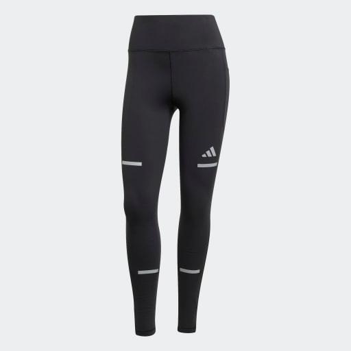 Adi365 Leggins til kvinder fra Adidas er sorte med høj linning, grå refleksstriber på lår og ben og et lille Adidas-logo på venstre lår. Vist mod en almindelig lys baggrund.