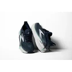 Et par Brooks Glycerin GTS 23 dame løbesko i Spellbound/Yucca/Pink, designet til stabilitet, vises oprejst mod en almindelig hvid baggrund med Brooks-logoet og de hvide såler synlige.