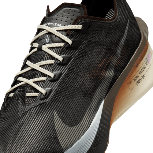 Nærbillede af Nike ZoomX Vaporfly Next% 4 til mænd i Velvet Brown/Soft Pearl-Black med hvide snørebånd, en struktureret overdel og en beigefarvet sål med ROAD RACING-tekst - ideel til dit næste maraton.