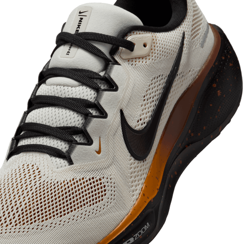 Et nærbillede af Nike Pegasus 41 Herre i Soft Pearl/Velvet Brown-Desert Ochre med overdel i mesh, sorte snørebånd, sort signatur-swoosh og en orange-sort prikket ReactX-skum-mellemsål.