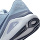 Nærbillede af bagsiden og sålen på Nike Structure 26 Herre i Lt Armory Blue/Diffused Blue-Ashen Slate, der viser stabilitet, struktureret hæl, Swoosh-logoer og slidbanemønster på den hvide og mørke ydersål i gummi.