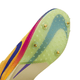 Nærbillede af Nike Dragonfly 2, Herre (Citron Pulse/Indigo Burst-Vivid Purple) sål med fire metalspikes og en struktureret, gennemsigtig plade med en blå Swoosh på en gul og lilla overdel.